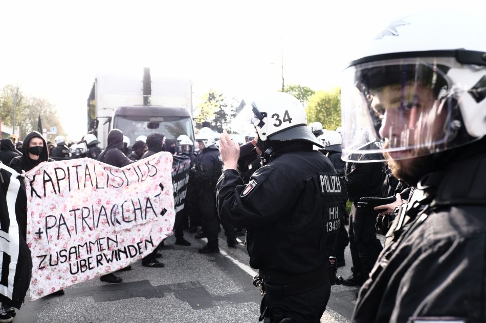 Die Polizei Hamburg kesselt die Teilnehmer der Demonstration ein. Auf einem Banner steht Kapitalismus Patriachat zusammen Überwinden